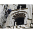 Un técnico de una empresa de trabajos verticales realizando fotos con el móvil de la Torre Sur de la Catedral de León