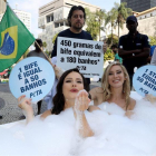 Dos activistas de la organización Personas a favor del Trato Ético a los Animales (PETA, en inglés) se bañan en una tina en el centro de Río de Janeiro hoy para denunciar que el consumo de carne supone el despilfarro de grandes cantidades de agua.