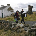 Dos oficiales se llevan la urna de la isla irlandesa de Inishbofin.