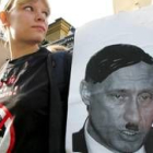 Una joven, del partido Yabloko, sostiene una fotografía de Putin caracterizado como Adolf Hitler