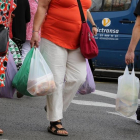 Consumidores con bolsas de plástico de asas