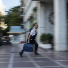 Un hombre entra dinero con una maleta en una sucursal bancaria de Atenas.