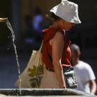 Una mujer pasa junto a una fuente en Córdoba. RAFA ALCAIDE