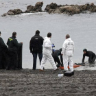 Agentes de la Guardia Civil retiran el cuerpo del subsahariano encontrado hoy en la playa del Tarajal de Ceuta.