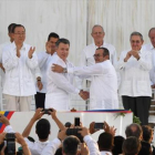 Santos y Timochenko se dan la mano entre los aplausos de Ki-mon, Castro y el rey emérito Juan Carlos, entre otras personalidades.