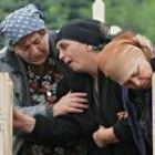 Tres mujeres lloran en el cementerio de Beslan