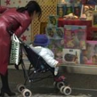 Una madre pasea a su hija pequeña por una céntrica calle madrileña