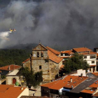 Un helicóptero participa en las labores de extinción del incendio para que no llegue a las casas.
