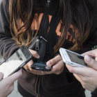 Unas adolescentes usan sus teléfonos móviles en Barcelona, en enero pasado.