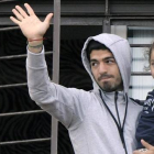 Luis Suárez saluda a los aficionados uruguayos desde el balcón de su casa con su hija.