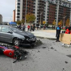 La motocicleta y el automóvil en primer plano, con las asistencias atendiendo al fallecido.
