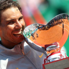 Nadal muerde la copa de campeón tras ganar a Nishikori en Montecarlo. SEBASTIEN NOGIER