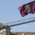 Un bombero coloca una bandera de León en el edificio de la Junta