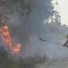 Imagen de archivo de un trabajador forestal apagando un incendio con un batefuegos, el pasado verano