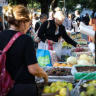 Una mujer compra frutas y verduras en una feria comunitaria para combatir la inflación.