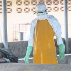 Dos sanitarios se dirigen a recoger el cadáver de una fallecida por ébola en Monrovia.