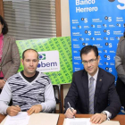 Representantes de la asociación de comerciantes y del Banco Herrero durante la firma del acuerdo.