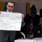 El presidente colombiano, Álvaro Uribe, sostiene la papeleta con su voto, ayer en Bogotá