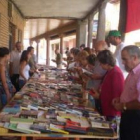 Varios vecinos ojean los libros que se ofrecieron en el mercadillo solidario.