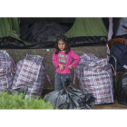Una niña espera junto a su tienda a ser trasladada en Grecia. NIKOS ARVANITIDIS / POOL