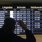 Una persona observa un panel de vuelos este sábado en el aeropuerto de Bilbao. LUIS TEJIDO