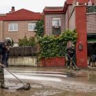 Bomberos limpian una zona afectada por el desbordamiento del río Cega en Viana de Cega (Valladolid) este lunes. NACHO GALLEGO