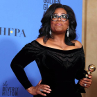 Oprah sostiene un premio en los Globos de Oro