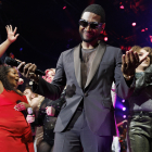 Usher junto a estudiantes de la clase de posgrado en el escenario del Berklee College of Music, después del concierto de graduación en Agganis Arena en Boston,