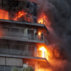 Dos personas aguardan en el balcón a ser rescatadas en el incendio declarado sobre las cinco y media de esta tarde en un quinto piso de un edificio de viviendas de Valencia que ha afectado totalmente al inmueble y se ha propagado a otro anexo.