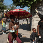 Habitantes caminan por una calle este sábado en Puerto Príncipe (Haití). Presuntos delincuentes fueron abatidos por la Policía Nacional de Haití durante un ataque al Palacio Nacional la noche del viernes en Puerto Príncipe, orquestado por la coalición de bandas armadas "Vivre Ensemble", según publicaron este sábado medios locales. EFE/ Johnson Sabin