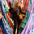 Una mujer entre trajes de flamenca hoy en una tienda en Sevilla.