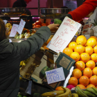 Una consumidora compra en un puesto de frutas y verduras en un mercado de abastos de Madrid, este miércoles.