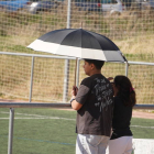 Dos personas se protegen del sol con un paraguas.