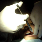 Un dentista atiende a una niña.