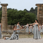 La actriz griega Mary Mina (d), en su papel de Gran Sacerdotisa de Olimpia, encendió la antorcha olímpica durante la tradicional ceremonia que se celebró este martes en las ruinas de la antigua Olimpia.