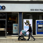 Una pareja camina junto a una sucursal del banco británico TSB en Londres, Reino Unido. EFE/Neil Hall/Archivo