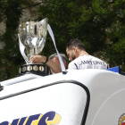 El capitán del Real Madrid Nacho Fernández (d) junto al trofeo en el autobús antes de dirigirse a Cibeles tras la recepción que ha tenido lugar en ayuntamiento de la capital como parte de los actos de celebración de la trigésimo sexta Liga conseguida por el equipo. EFE/Zipi Aragón