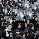 Mujeres iraníes vestidas con chadores negros sostienen carteles del difunto presidente iraní Ebrahim Raisi mientras participan en una ceremonia de luto en Teherán, Irán, el 20 de mayo de 2024.EFE/ Abedin Taherkenareh