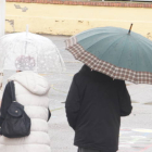 Dos personas se protegen de la lluvia con un paraguas.