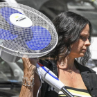 Una mujer lleva un ventilador recién comprado para protegerse del calor.