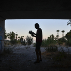 Miguel Rosa, natural de Córdoba, lee un libro bajo el puente en el que reside en Roquetas de Mar (Almería) y desde donde desarrolla su pasión que es escribir, un hombre sin techo que llegó a esta provincia para ganarse la vida bajo el plástico de los invernaderos. EFE / Carlos Barba