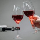 Brindis con vino entre humano y máquina.
