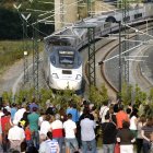 Familiares de víctimas observan el paso del tren de las 20:40 en la curva de Angrois, justo un año después del accidente, durante el acto del aniversario de la tragedia ferroviaria en la que murieron 79 personas, esta tarde en Angrois, en Santiago de Compostela.