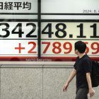 Tokyo (Japan), 06/08/2024.- A pedestrian walks past a display showing the Nikkei Stock Average in Tokyo, Japan, 06 August 2024. Tokyo's stock benchmark recorded its largest single-day gain in history, gaining over 3,200 points, after losing over 4,400 points on 05 August 2024, bigger than the 'Black Monday' historic loss in 1987. The Nikkei Stock Average surged 3,217.04 points, or 10.23 per cent, to close at 34,675.46 on 06 August 2024. (Japón, Tokio) EFE/EPA/KIMIMASA MAYAMA