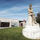 Estatua del pensador en el Campus, con el Edificio de Gestión Académica al fondo.