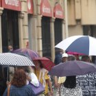 Varias personas se protegen de la lluvia en Ordoño.