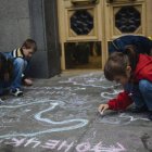 Varios niños refugiados de las regiones del este de Ucrania y Crimea dibujan con tiza en el suelo durante una protesta en la entrada del Parlamento ucraniano en Kiev.