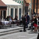 Varias personas disfrutan del buen tiempo en una terraza de León.