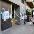 Peatones pasan este viernes por delante del local donde dos personas que dormían en su interior han fallecido esta madrugada a causa de un incendio, según los datos iniciales facilitados a EFE por fuentes cercanas a la investigación. EFE/ Raquel Manzanares