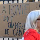 Una mujer pasa junto a un cartel en apoyo a Giséle Pelicot en Montpellier, Francia.